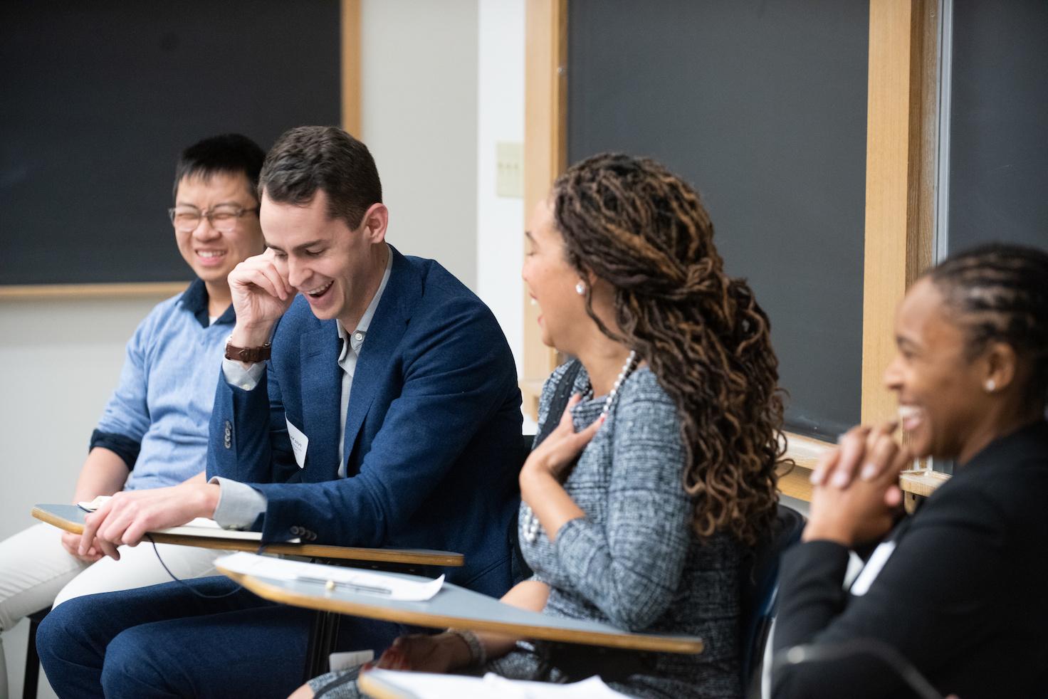 People laughing while sitting at desks